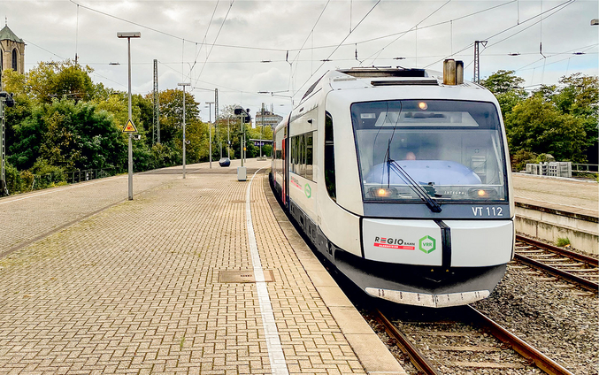 Weiße Eisenbahn von Regiobahn fährt in einem Bahnhof ein
