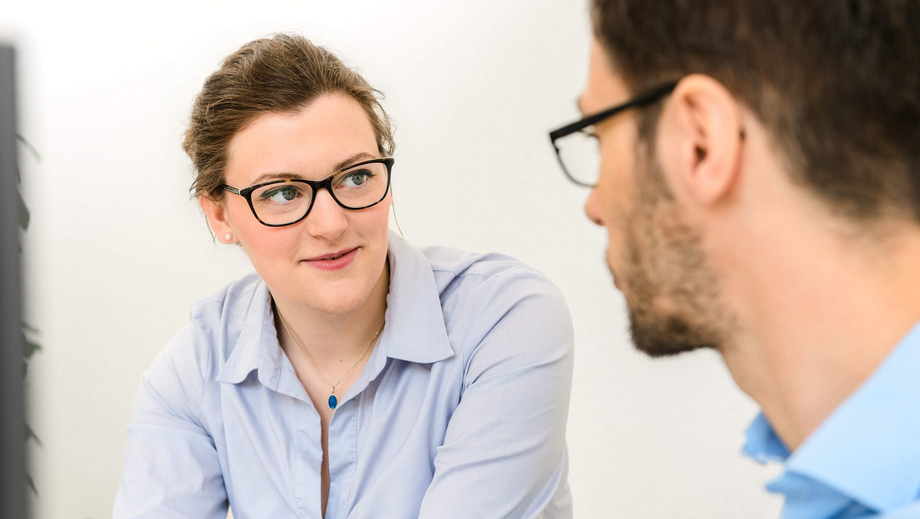 Frau im Gespräch mit einem Kollegen