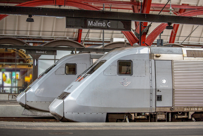 Zwei silber-graue SJ Züge stehen auf einem Bahngleis in Malmö.