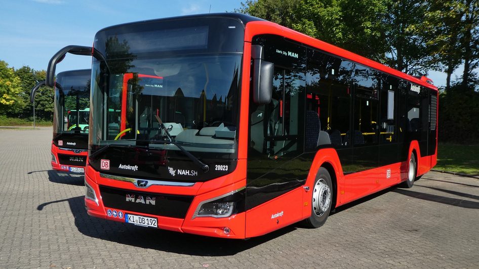 Zwei geparkte, rote DB Regio Busse