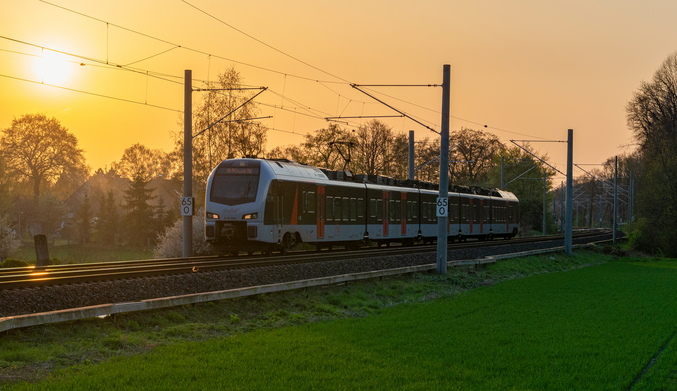 Zug auf Schienen vor einem Sonnenuntergang