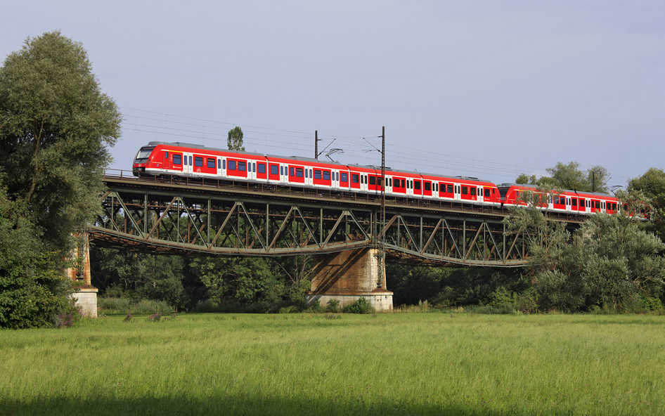 Rote Eisenbahn von S-Bahn Stuttgart überquert eine Brücke in einer ländlichen Region